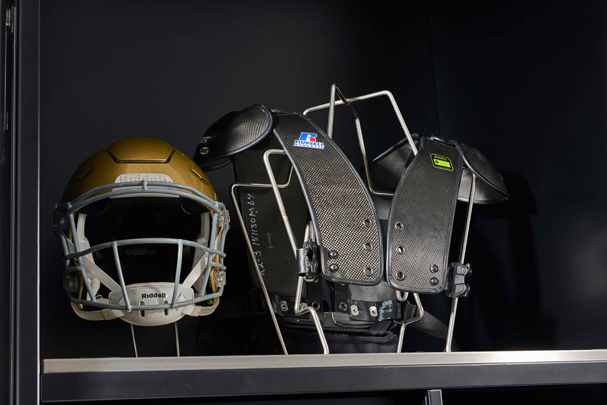 Footballhelm und Schulterpolster im Regal aufbewahrt.
