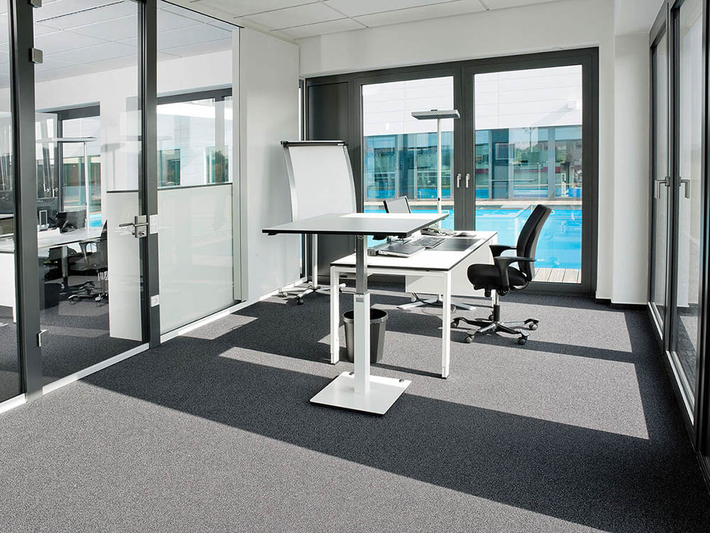 Großes Büro mit Stehpult, umgeben von Glaswänden, nahe einem Pool.