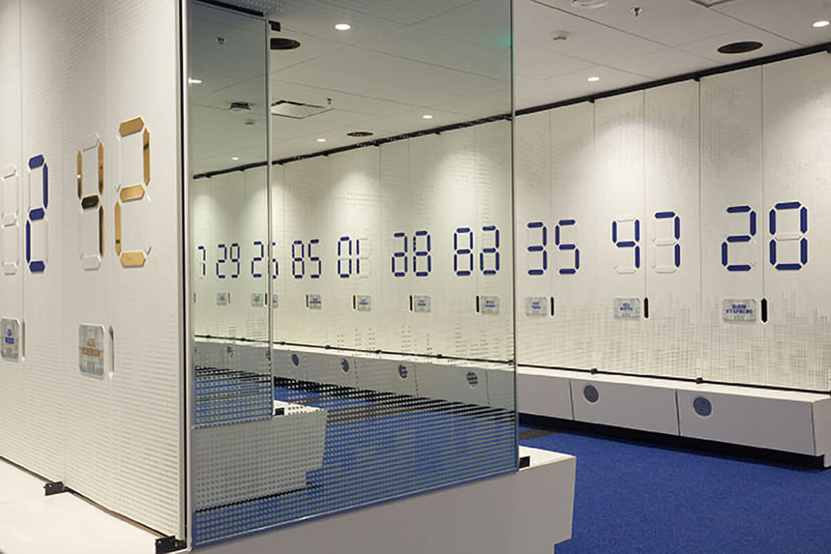 Spiegelwand reflektiert große digitale Zahlen in modernem Innenraum.