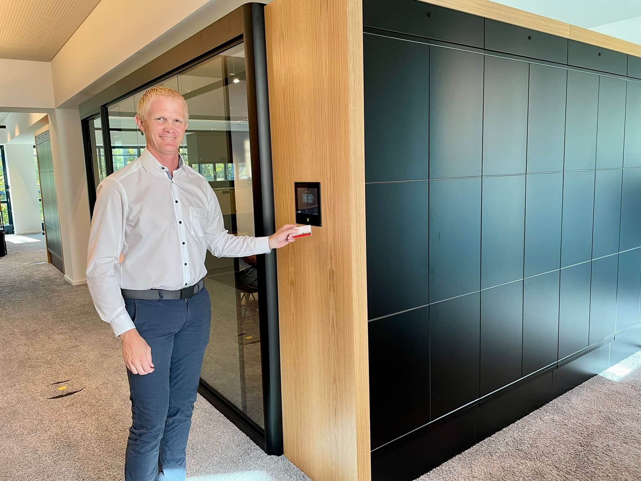 Person zeigt Karte an Wandbildschirm im Büroflur.