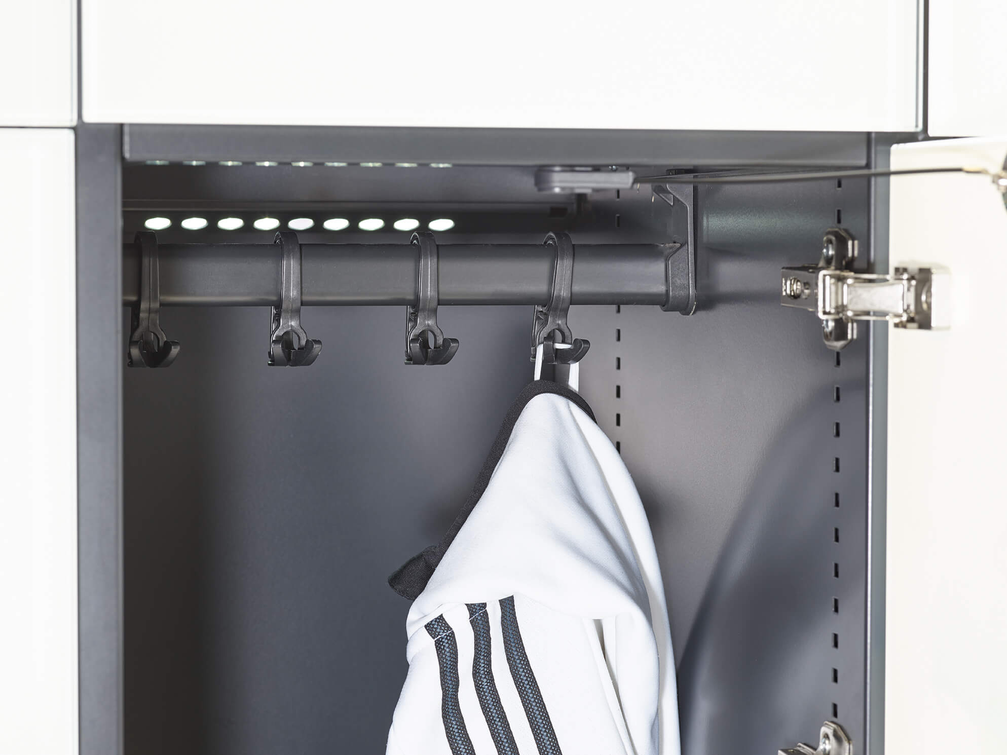 Innenansicht eines Schranks, zeigt Kleiderbügel mit Jacke dran.